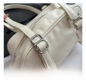 Detailed macro shot of adjustable leather shoulder strap with silver metal buckle