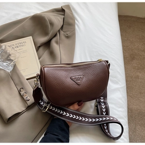 Detail of dark brown lychee leather pillow bag with stylish jacquard wide strap