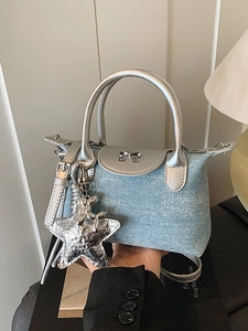 Mini light blue denim handbag with silver rhinestones and star pendant on display