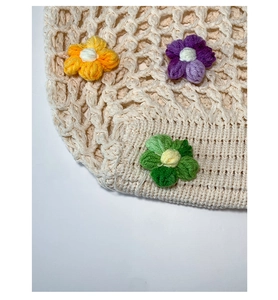 Détail de sac cabas au crochet fait main avec mailles évidées et fleurs 3D colorées