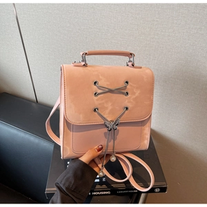 Mini sac à dos rose en cuir avec breloque papillon en métal et perles sur un coffret