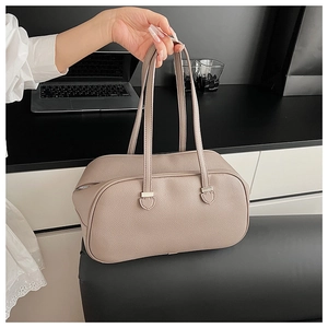 Close-up of litchi textured leather handbag with silver zipper and refined hardware