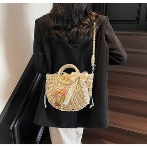 Lace straw bag with floral details and drawstring lining shown on model's back