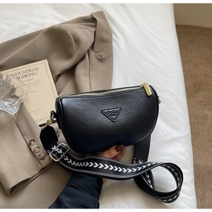 Detail of black lychee grain leather pillow bag with stylish geometric wide strap