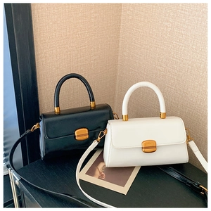 Detailansicht der Premium-Ledertaschen in Schwarz und Weiß mit Goldbeschlägen