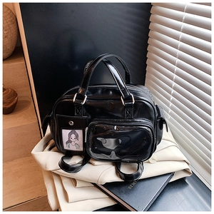 Detail of black glossy leather multipurpose bag with transparent PVC window and silver hardware