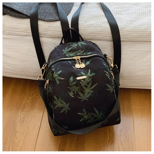 Detail of waterproof nylon backpack featuring bamboo leaf print and gold hardware zippers