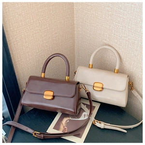Detaillierte Nahaufnahme brauner und beiger Vintage-Umhängetaschen mit Goldschnallen