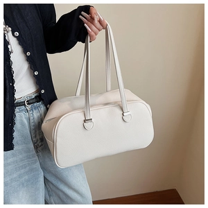 Detail of white lychee leather texture and silver hardware on a medium shoulder bag