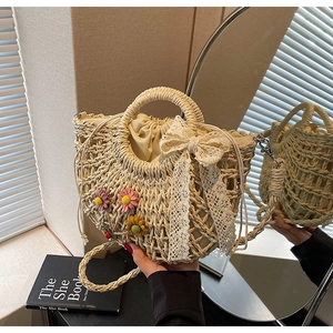 Detailed straw woven bucket bag featuring lace bow, floral accents and drawstring liner