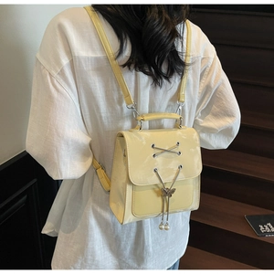 Détail du mini sac à dos en cuir verni jaune avec papillon en métal et perles