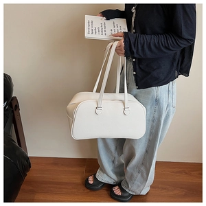 Close-up of white lychee leather texture on a minimalist fashion bowling bag