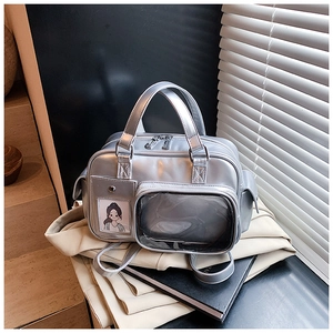 Detail of silver metallic ita bag with a transparent display window and cartoon card