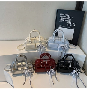 Collection of shiny Boston bags in five colors with lace bow charms and twin pockets
