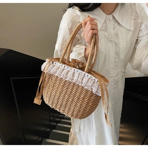 Detail view of woven straw tote bag with delicate white lace trim and small bead accents