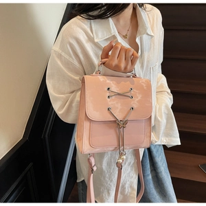 Mini sac à dos en cuir verni rose avec pendentif papillon et laçage élégant