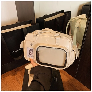 Detail of cream white ita bag showing glossy PU leather finish and transparent PVC window