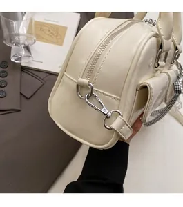 Detailed shot of beige Boston bag with glossy finish and silver-tone metal hardware