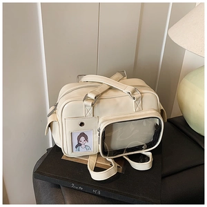 Detail view of the cream white commuter bag featuring a transparent PVC display pocket