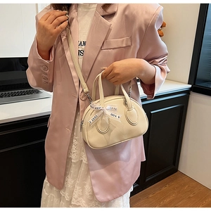 Chic cream mini square bag with ribbon bow detail shown on professional model