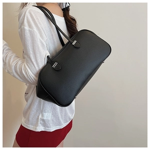 Detailed view of black pebbled leather handbag featuring dual handles and silver hardware