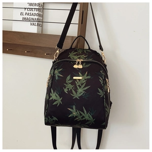 Detail of black backpack with green bamboo leaf prints and premium gold hardware accents