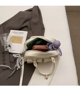 Detail showing high capacity of cream Boston bag with phone, wallet and umbrella