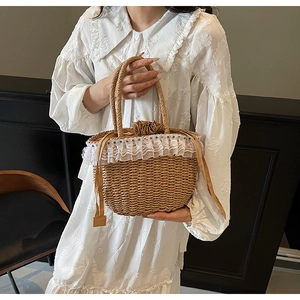Detail of straw woven handbag with white lace trim and colorful beads in retro style