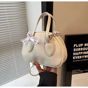 Detail of cream white litchi pattern leather handbag with decorative printed ribbon