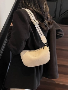 Cream lychee leather crescent bag with black and white jacquard wide strap and gold hardware
