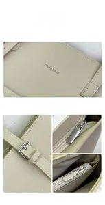 Detailed view of beige leather tote bag with silver zipper and DADI BAGS logo