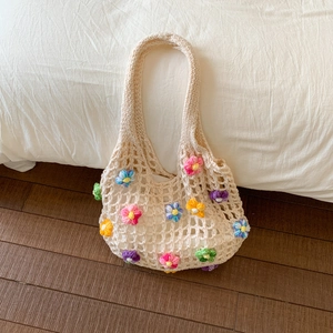 Détail d'un sac cabas en crochet fait main avec fleurs 3D colorées et maille tressée