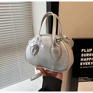 Close-up of metallic silver mini handbag with lychee pattern and organza ribbon detail