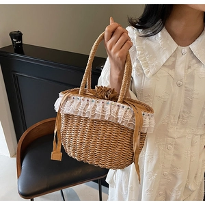 Detail of hand-woven straw bag featuring delicate lace trim and drawstring closure