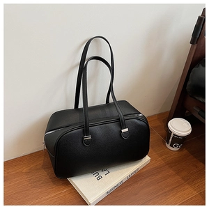 Close-up of black litchi pattern leather tote bag with elegant top zipper detail