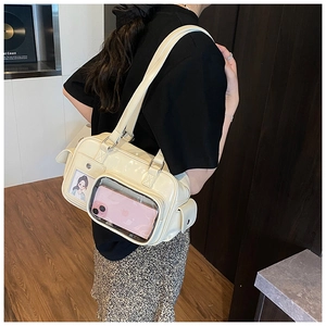 Detail view of cream shoulder bag featuring transparent window for plushies and accessories