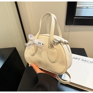 Detail of cream white pebbled leather mini bag with decorative bow and top handle