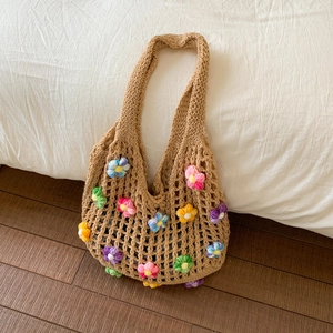 Détail de fleurs au crochet 3D colorées sur un sac de plage tissé ajouré kaki