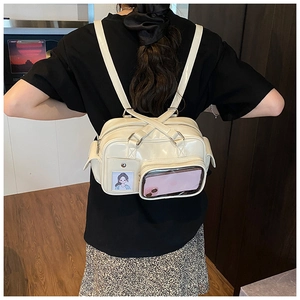 Detail view of the clear PVC display window and side pocket on an ivory PU backpack