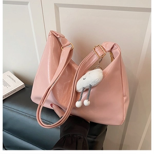 Pink faux leather hobo bag featuring a cute white cloud charm and adjustable strap