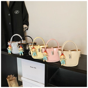 Detail view of five luxury mini bucket bags in various colors with cute cartoon charms