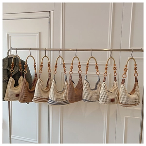 Détail de sacs à bandoulière au crochet multicolores avec sangles en perles de bois