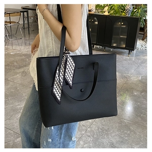 Close-up of black lychee grain tote bag with snap button pocket and silk scarf detail