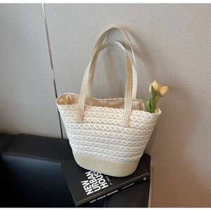 Dettaglio della borsa tote in pizzo bianco con manici intrecciati e fiori di tulipano