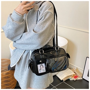 Detail of black glossy patent leather tote with transparent window and cartoon insert card