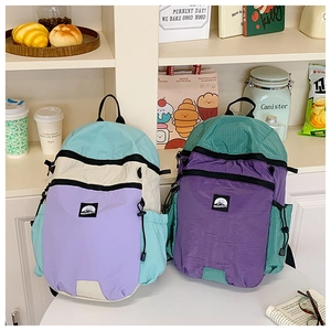 Detail of color-blocked nylon backpacks with durable ripstop texture and large capacity