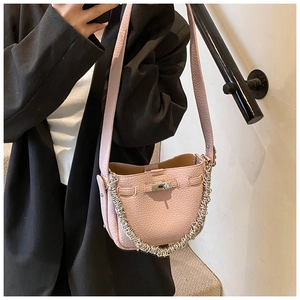 Dettaglio borsa a secchiello rosa in pelle martellata con chiusura a scatto argento