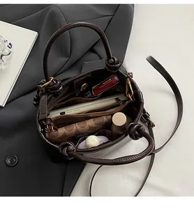 Vue de dessus de l'intérieur du sac seau en cuir montrant les compartiments spacieux