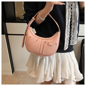 Close-up of pink crescent handbag featuring lychee texture leather and silver rivets