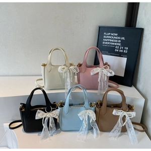 Detail of five-color leather bucket bags with pearl bow charms and lychee texture